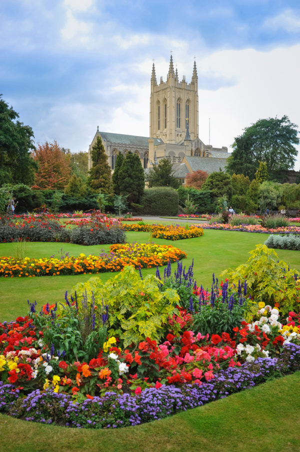Busy St Edmunds Cathedral with a beautiful flower garden, England